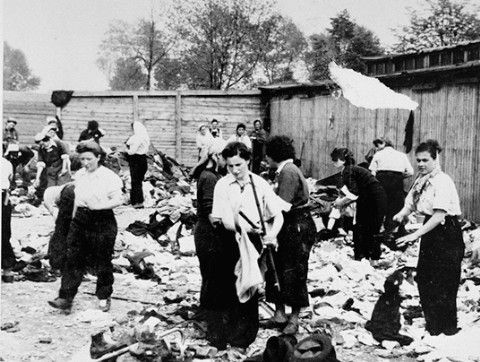 Female prisoners ort the confiscated property of a transport of Jews from Subcarpathian Rus at a warehouse in Auschwitz-Birkenau